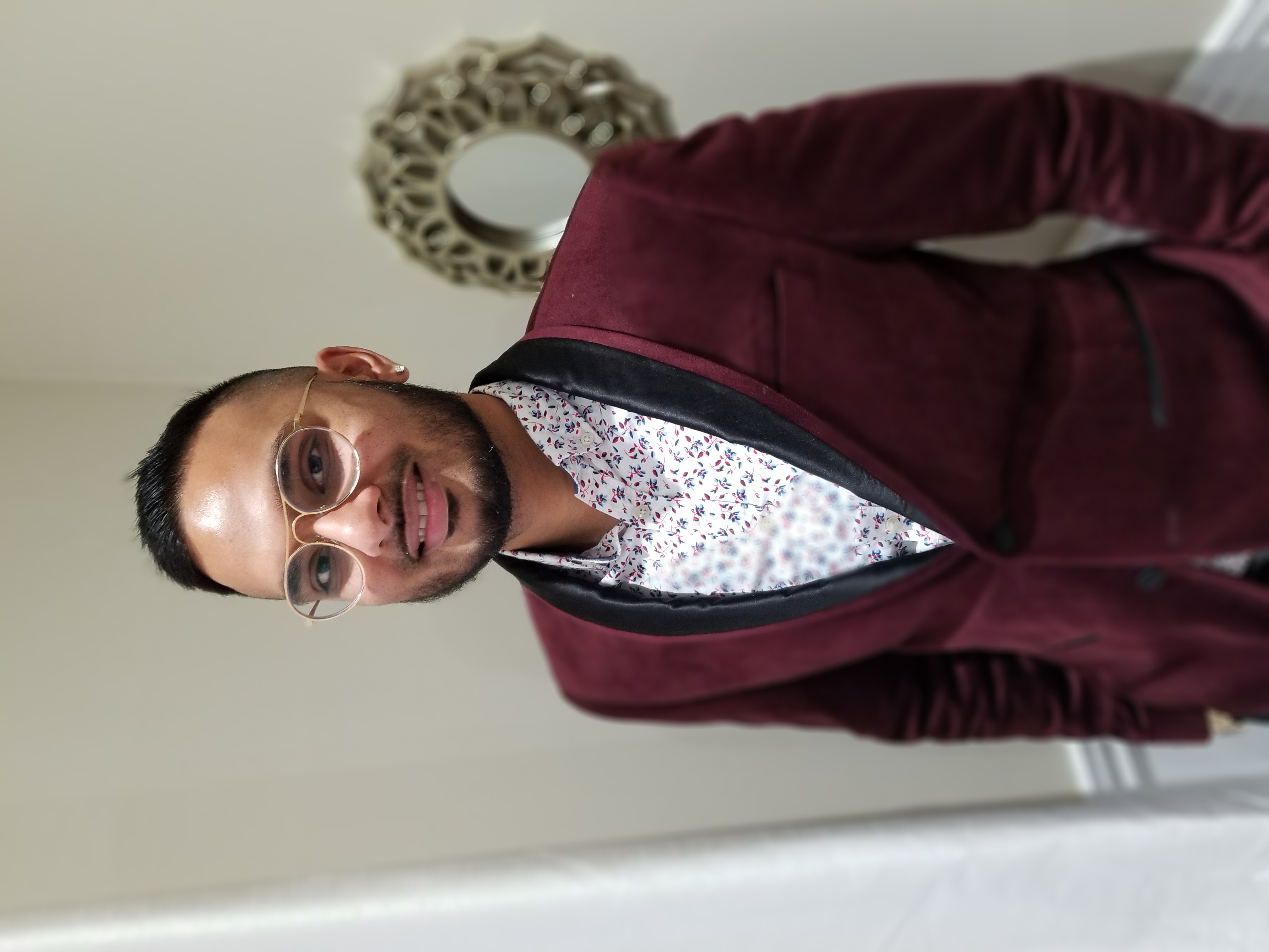 Michael Singh wearing a red suit